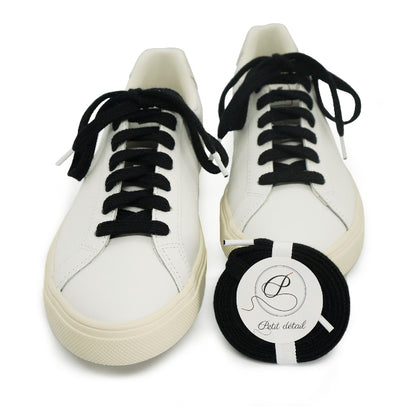 Lacets en coton biologique certifié GOTS Noir Eclipse et Blanc - paire emballée avec une autre paire mise en scène sur des sneakers - Paire faisant partie d’un ensemble Lacets Made in France et Bouton de Manchette - vue de face - Petit-détail.com 